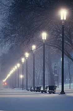Photo of city snow scene with lamps lit